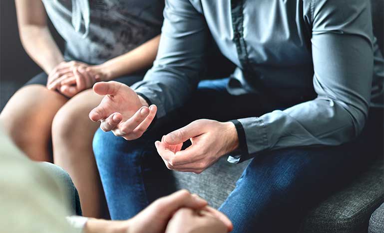 People sitting. Image is close up on person with their hands facing up.