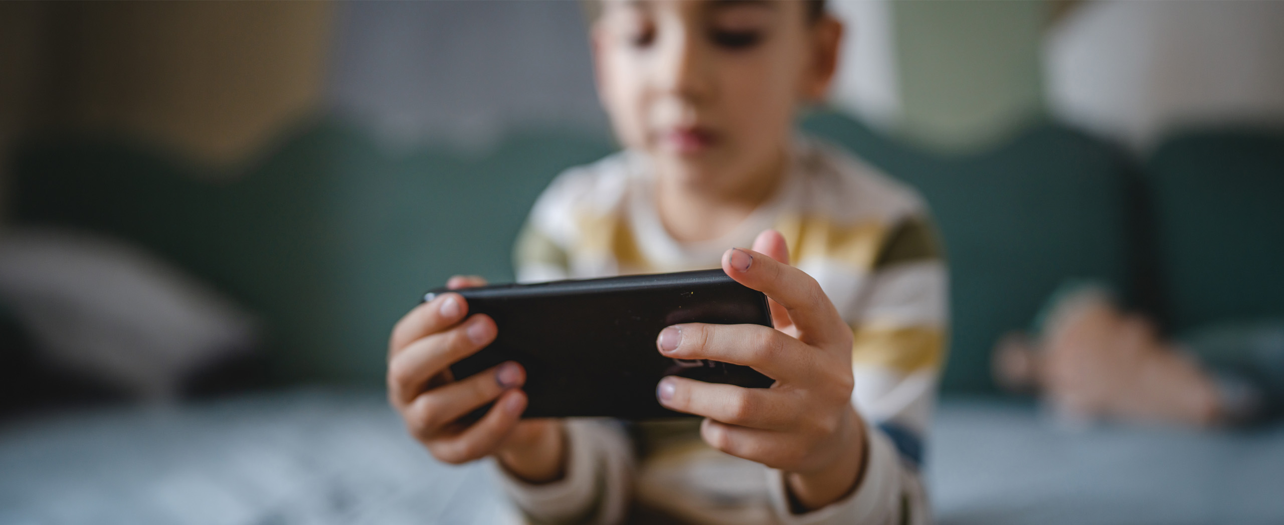 Child holding a smartphone horizontally with both hands