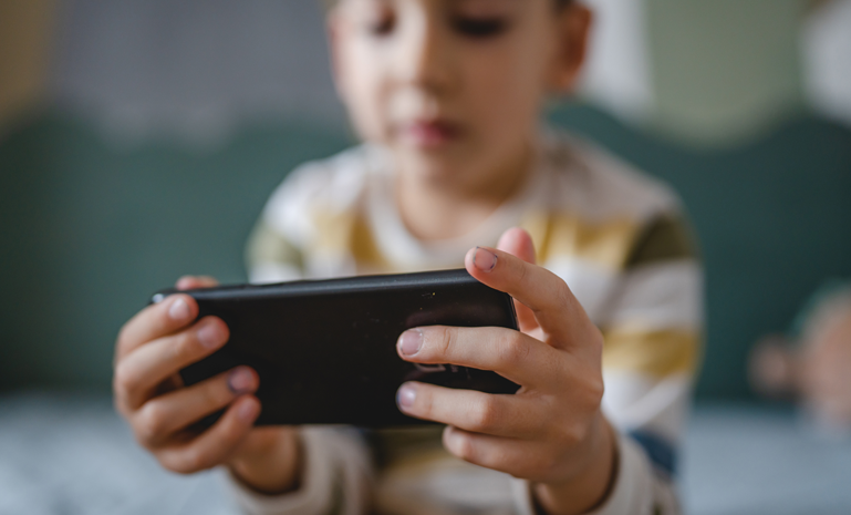 Child holding a smartphone horizontally with both hands