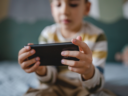 Child holding a smartphone horizontally with both hands