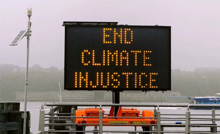 Street construction sign that says "End Climate Injustice"