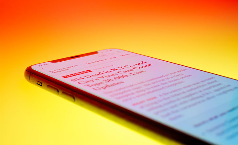 Phone showing news on lit background