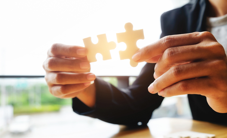 Close up on person holding two puzzle pieces