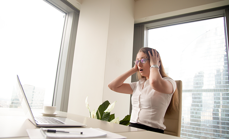 Woman at her desk realizing she made a mistake