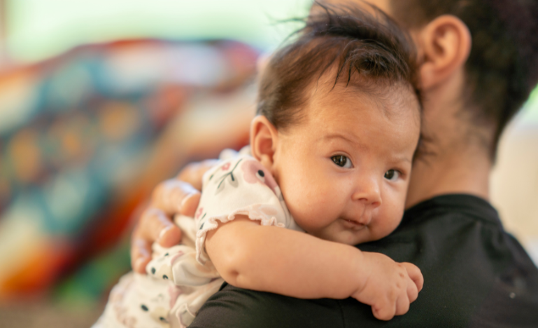 An Indigenous baby in their father's arms