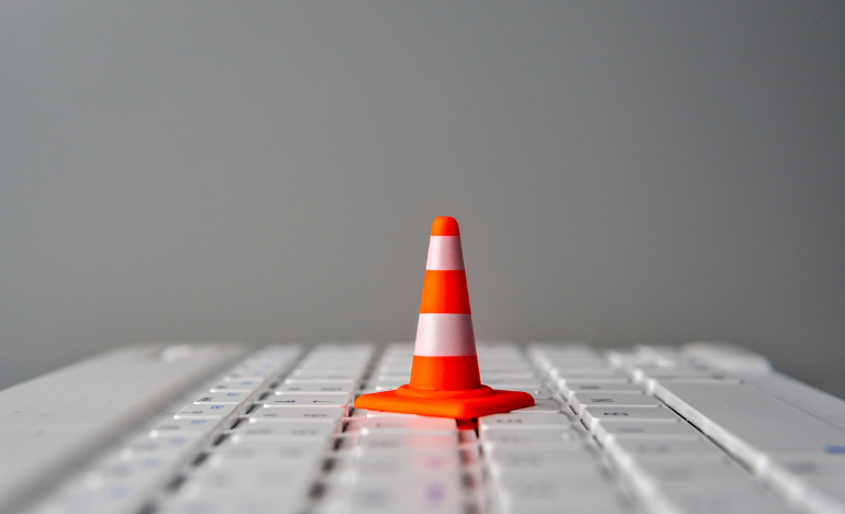 Un cône de signalisation miniature sur un clavier d'ordinateur