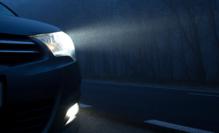Car headlights shine in the dark