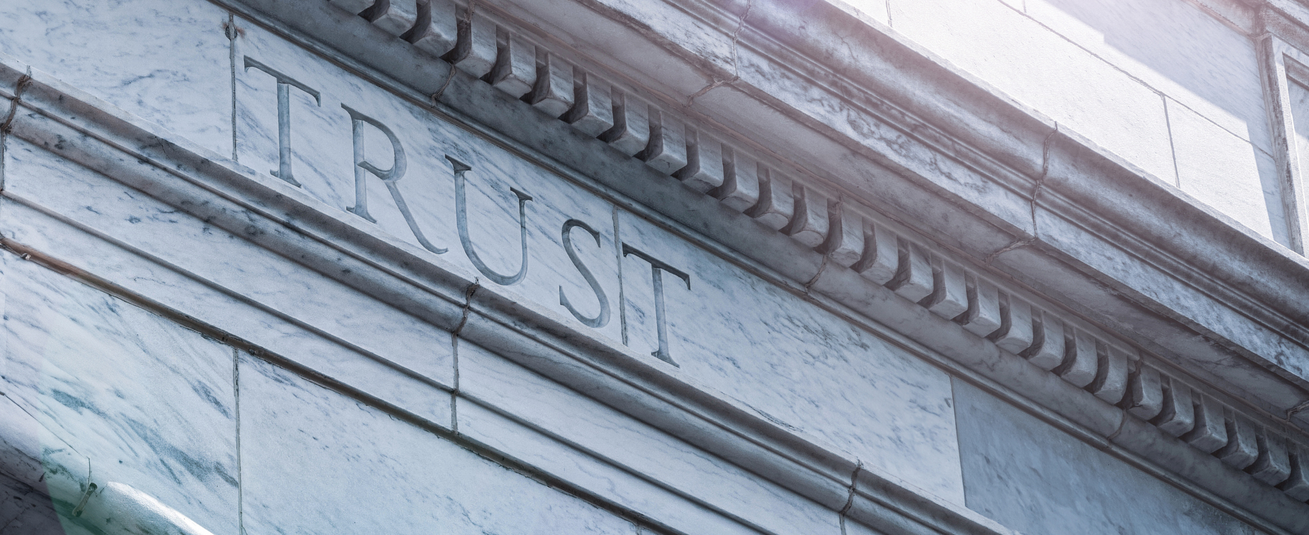 The word 'trust' etched into a stone courthouse