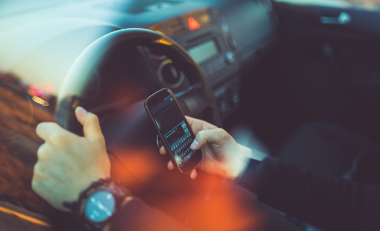 A man uses a cell phone while driving a car