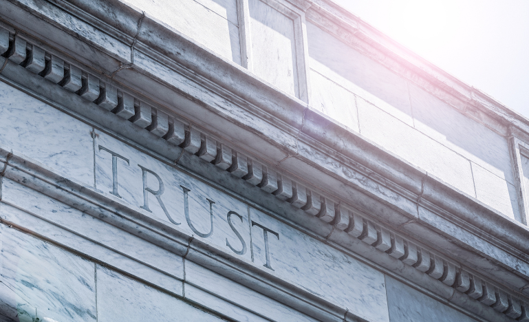 The word 'trust' etched into a stone courthouse