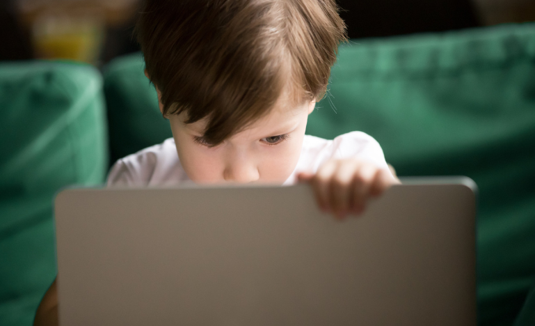 Un jeune enfant regardant un écran d'ordinateur
