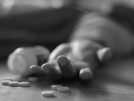 A man lays on the floor, unconscious due to a drug overdose