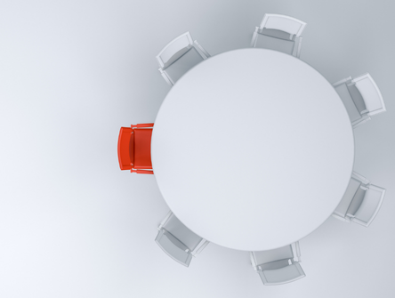 A red chair at a table surrounded by white chairs