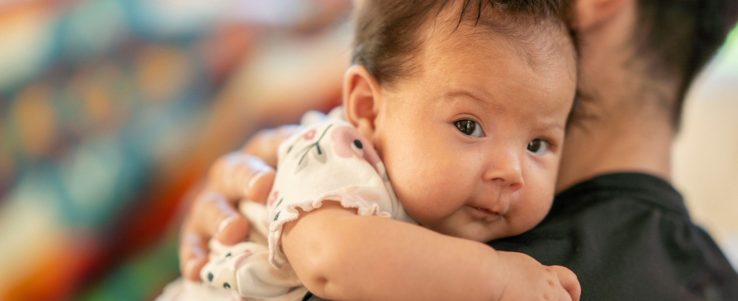 An Indigenous baby in their father's arms