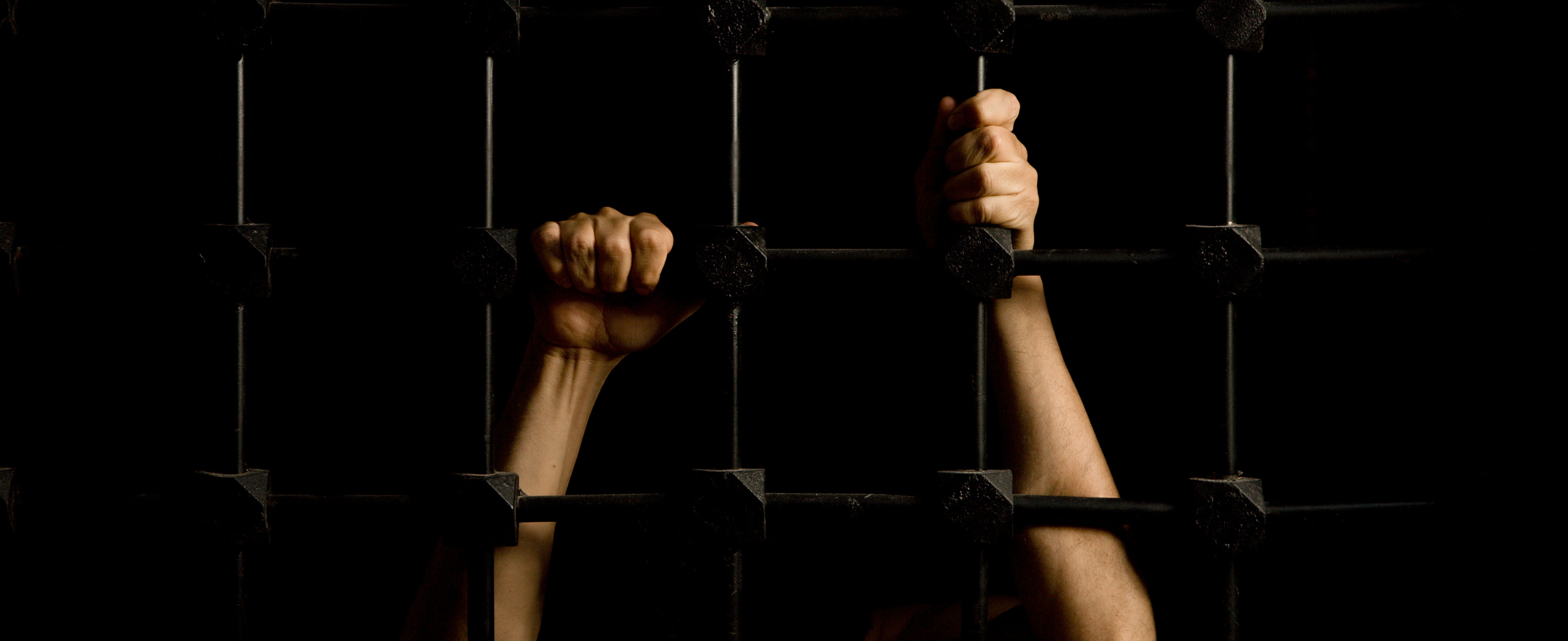 Hands of a prisoner through cell bars