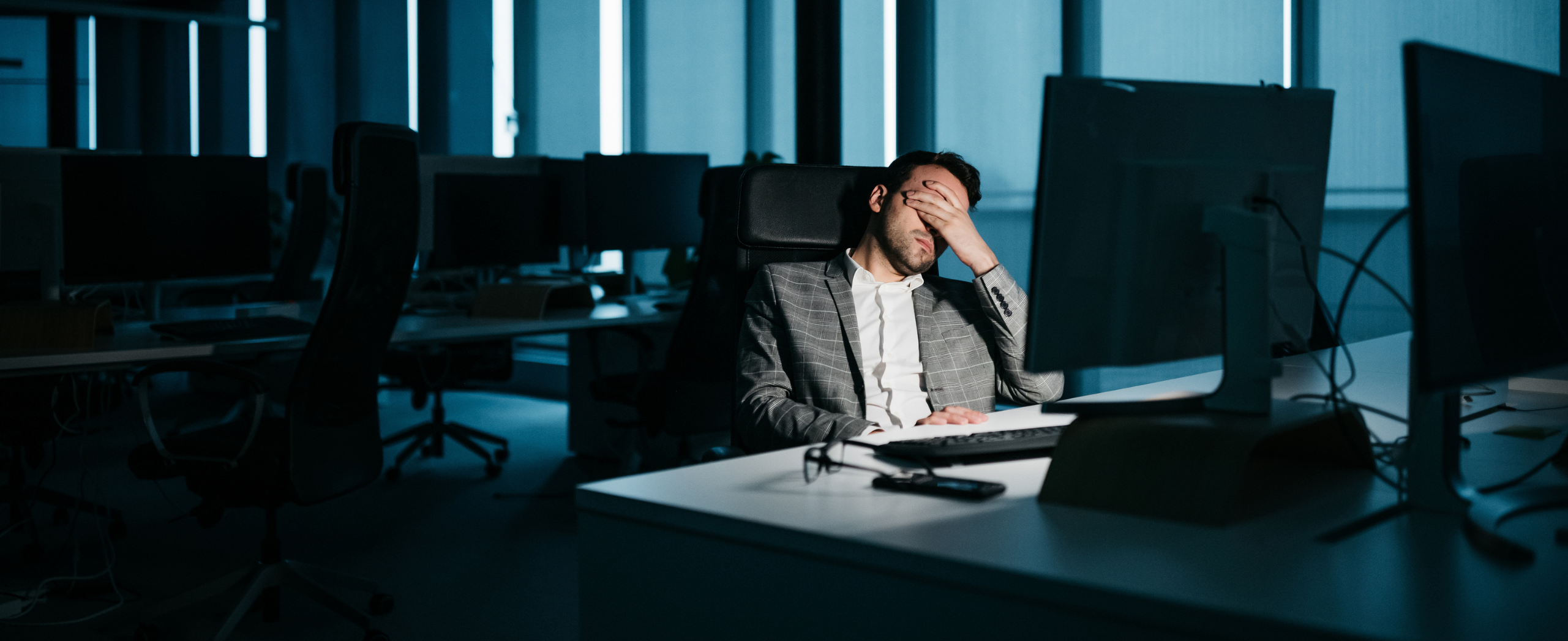 A stressed lawyer in front of their office computer at night.