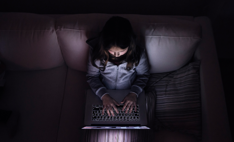 A child sits alone while on a computer