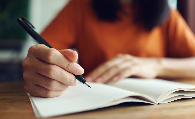 A student takes handwritten notes in class