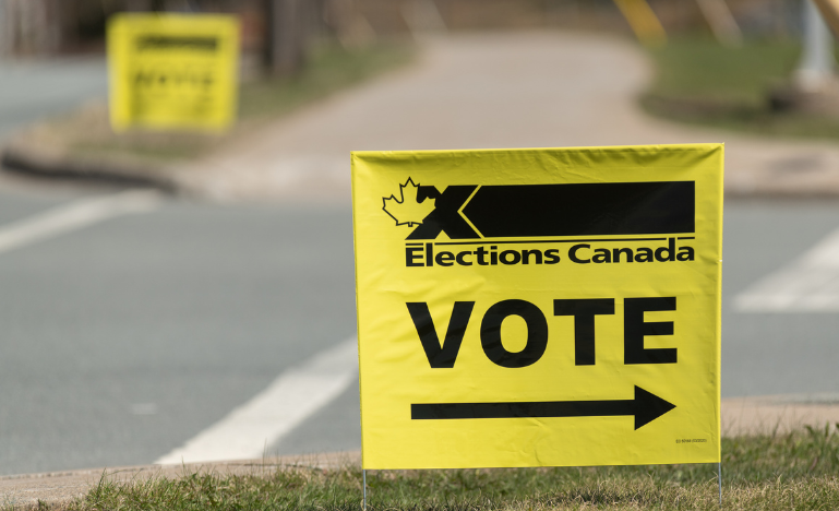 Yellow Elections Canada voting sign on a corner