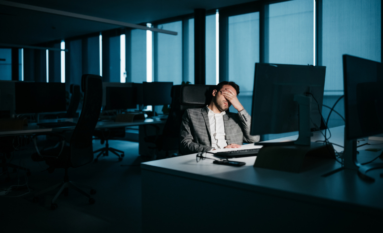 A stressed lawyer in front of their office computer at night.