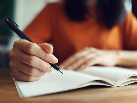 A student takes handwritten notes in class