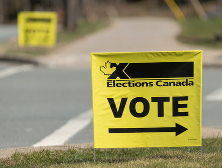 Yellow Elections Canada voting sign on a corner