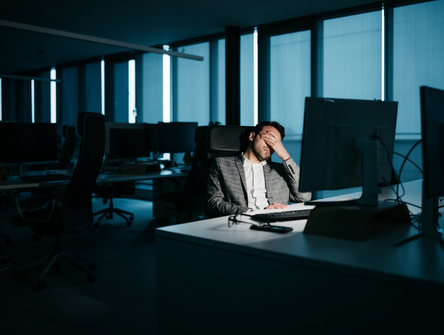 A stressed lawyer in front of their office computer at night.